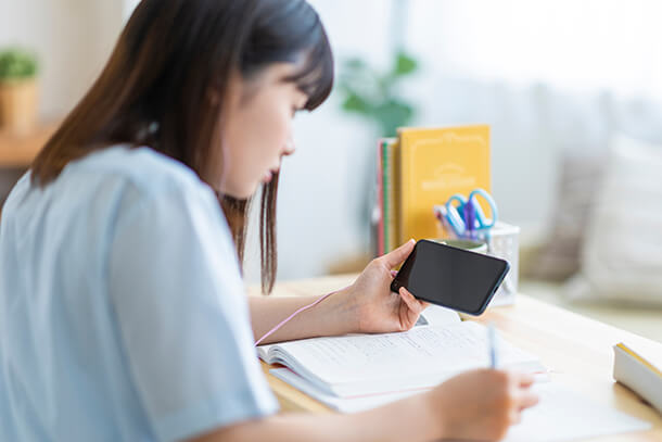 スマホで学習する女性の画像