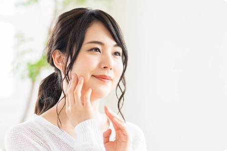 顔を触る女性の画像