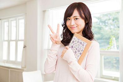 女性が笑顔でピースサインしている
