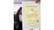 女性が合格証書を手に持っている
