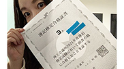 女性が合格証書を手に持っている