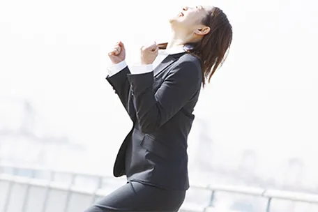 スーツ姿の女性が喜んでいる