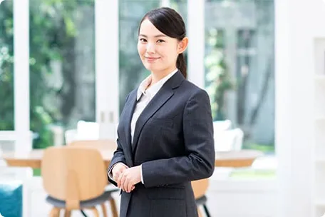 スーツ姿の女性がほほ笑む
