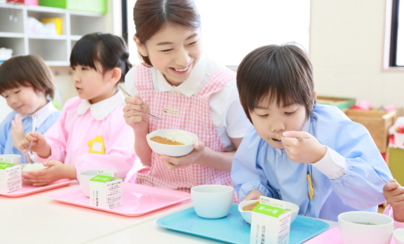 子どもの食事を見守る保育士のイメージ
